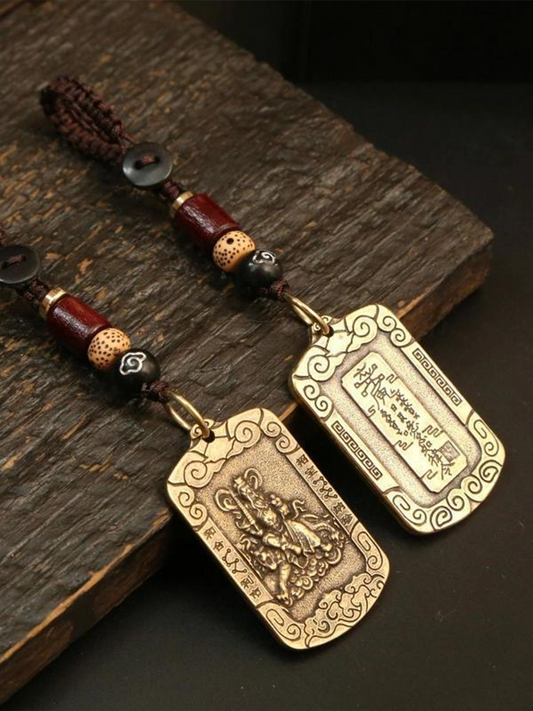 These are two Zhao Gongming amulet pendants from Chinese Taoism, displayed on the table.