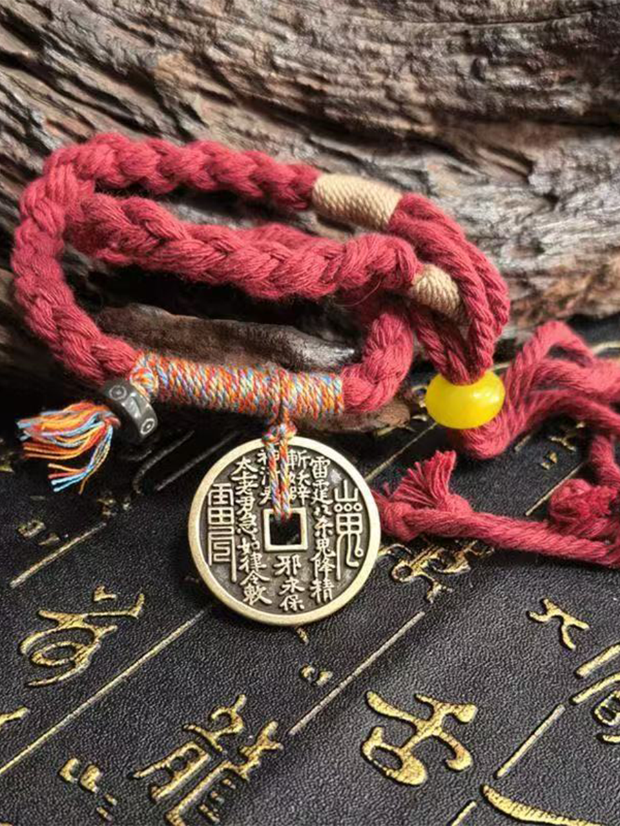 This is a red braided rope bracelet paired with a Taoist mountain spirit charm.