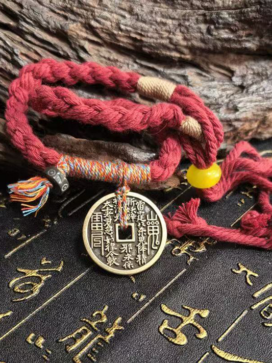 This is a red braided rope bracelet paired with a Taoist mountain spirit charm.