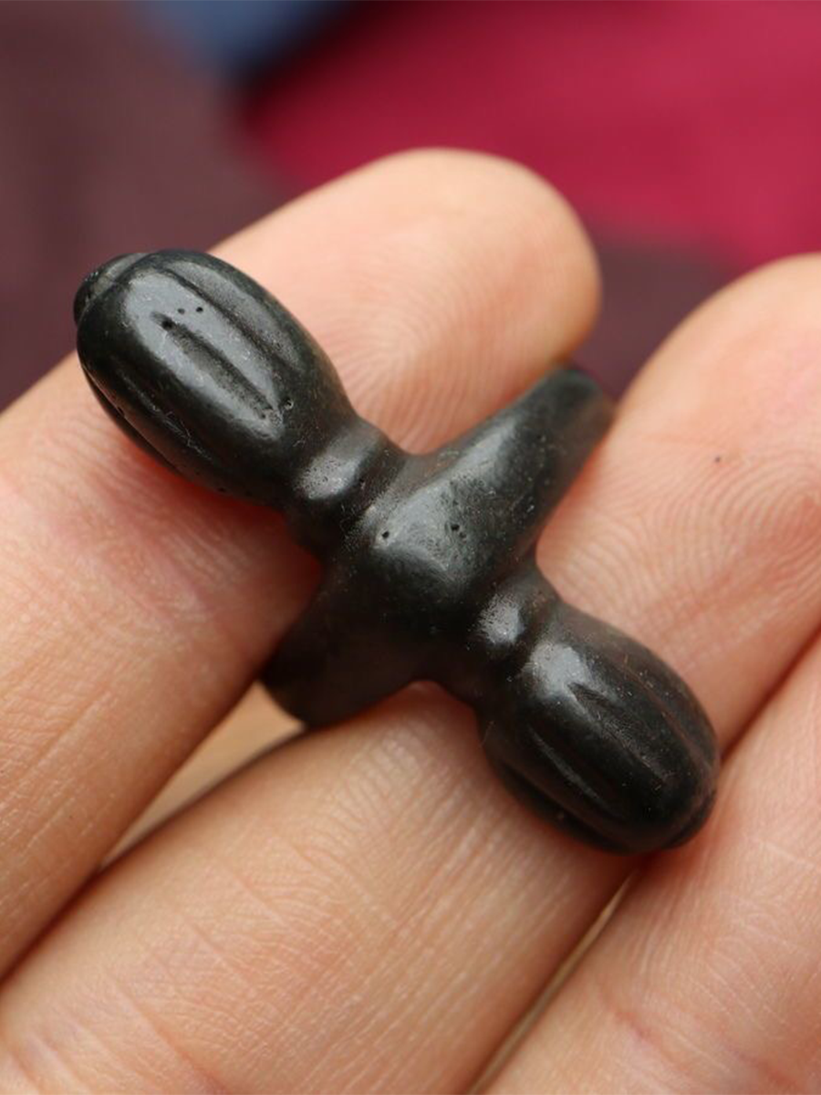 A vajra (a sacred metal object) is placed on a person's finger.
