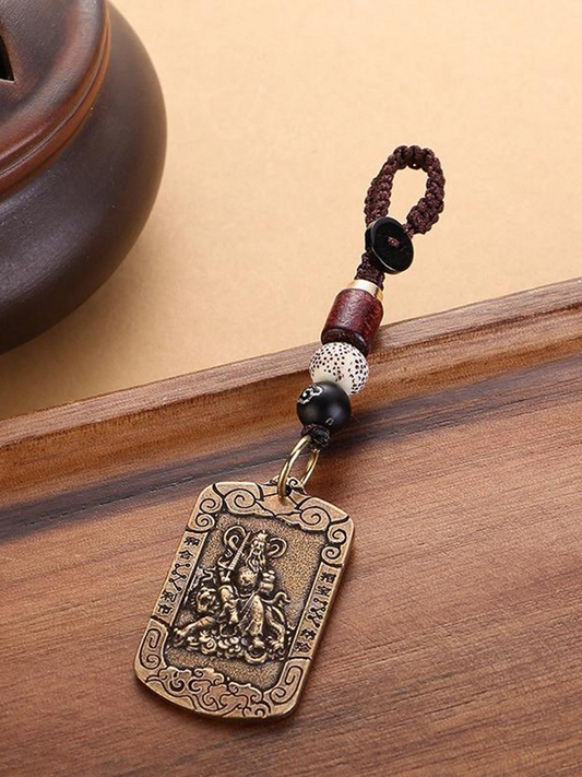 This is a Zhao Gongming amulet pendant from Chinese Taoism, displayed on the table.