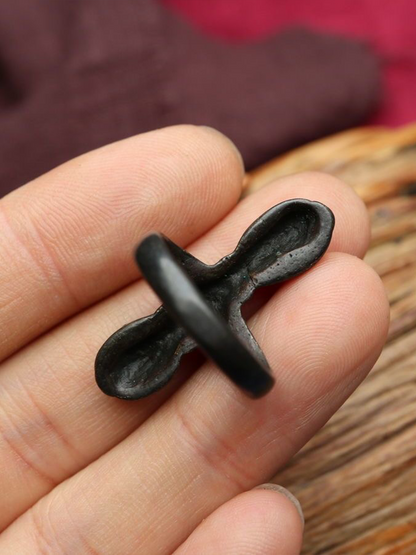 A vajra (a sacred metal object) is placed on a person's finger.