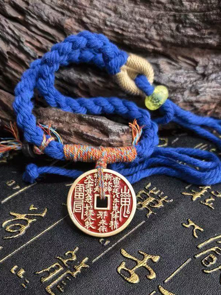 This is a blue braided rope bracelet with a Taoist mountain spirit motif.
