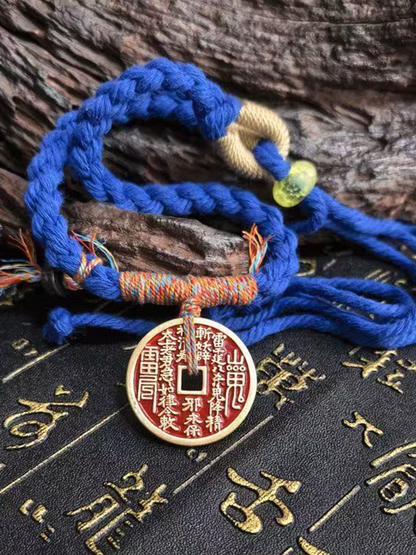 This is a blue braided rope bracelet with a Taoist mountain spirit motif.