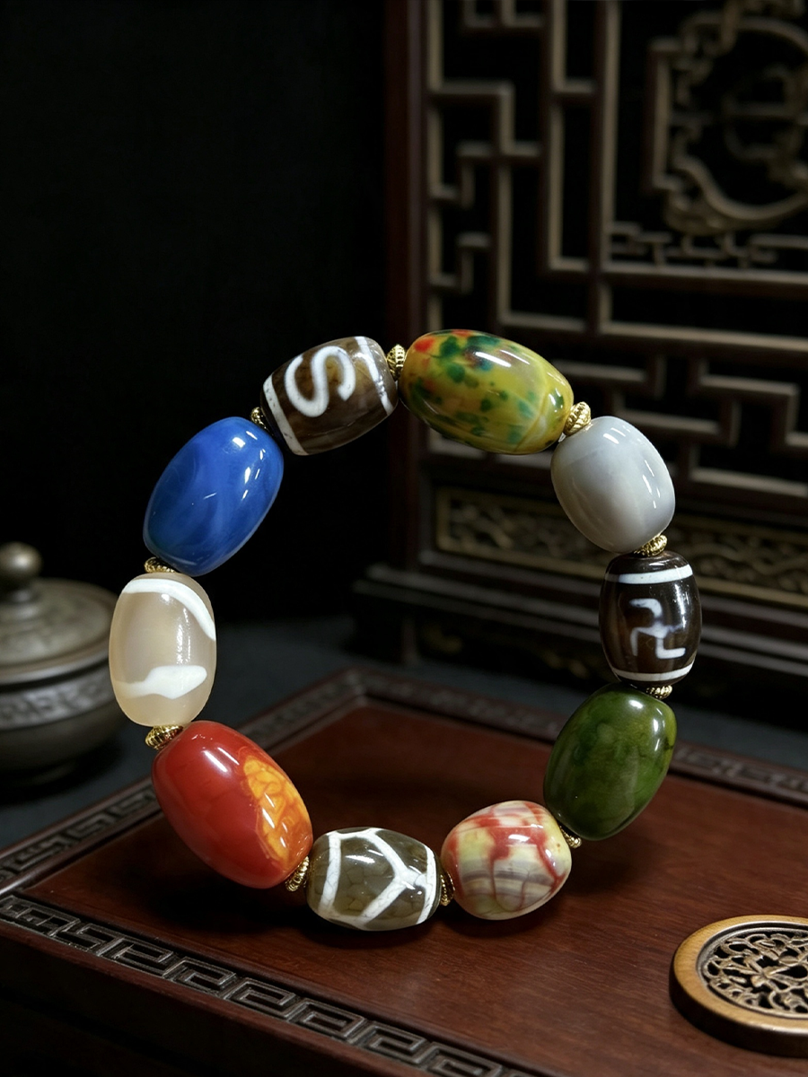 A beaded bracelet with nine distinct, polished stone beads in various colors including blue, green, red, orange, white, and brown, separated by small gold spacer rings, displayed on a dark wooden surface.