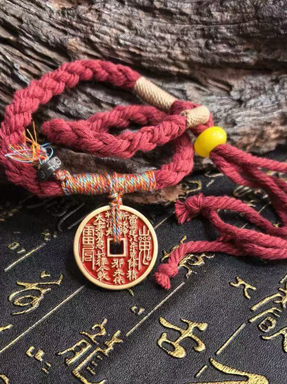 This is a red braided rope bracelet paired with a Taoist mountain spirit charm.