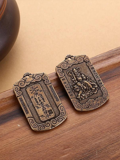 These are two Zhao Gongming amulet pendants from Chinese Taoism, displayed on the table.