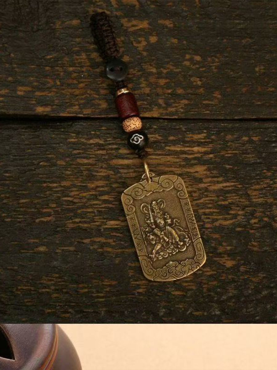 This is a Zhao Gongming amulet pendant from Chinese Taoism, displayed on the table.
