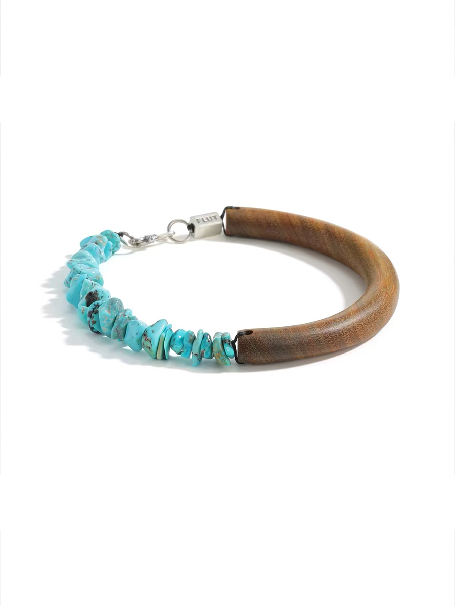 A rustic wooden bracelet with a section of natural turquoise chip beads and a silver clasp, photographed on a clean white background.