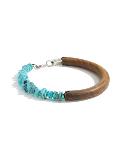 A rustic wooden bracelet with a section of natural turquoise chip beads and a silver clasp, photographed on a clean white background.